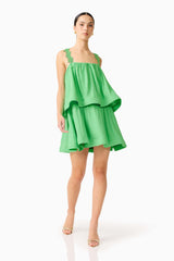 Brunette model wearing the Emilie Tiered mini Dress in Kelly Green posed shot