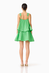 Brunette model wearing the Emilie Tiered mini Dress in Kelly Green back shot