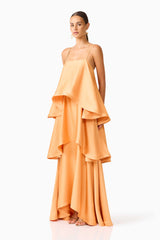 Brunette model wearing the Tilly Tiered Maxi Dress in Orange side shot