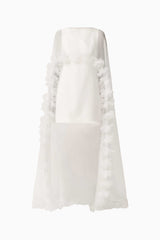 Model wearing the Ellie Cape Mini Dress in White with floor length cape with floral trim ghost shot