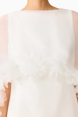 Model wearing the Ellie Cape Mini Dress in White with floor length cape with floral trim detail shot