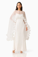 Ellie Cape Maxi Dress in White with a cape with floral trim detailing & column silhouette posed hand on hip shot