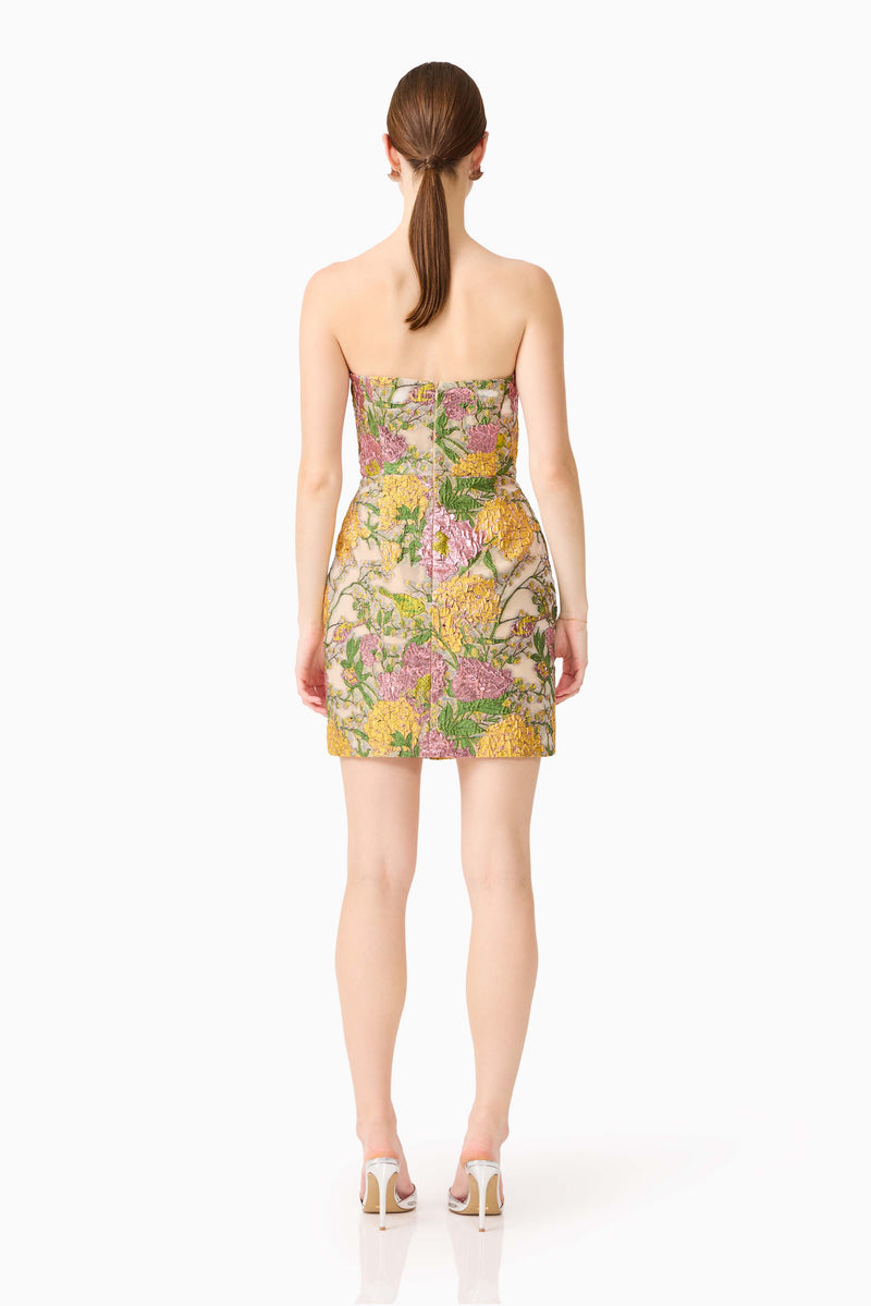 Brunette model wearing the Patricia Strapless Mini Dress in Gold & Purple Floral back shot