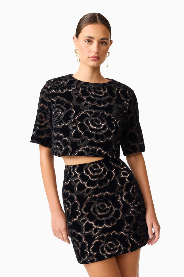 Brunette model wearing the Eris Short Sleeve Set in Black close up leaning shot 