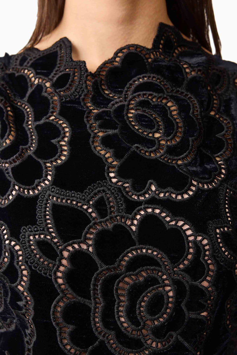 Brunette model wearing the Eris Fit & Flare Midi Dress in Black detail shot