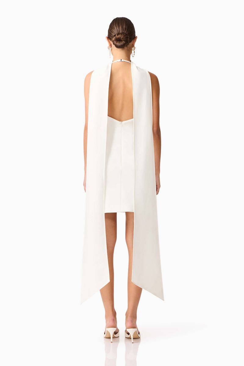 Brunette model wearing Mira Halter Mini Dress in White back shot 