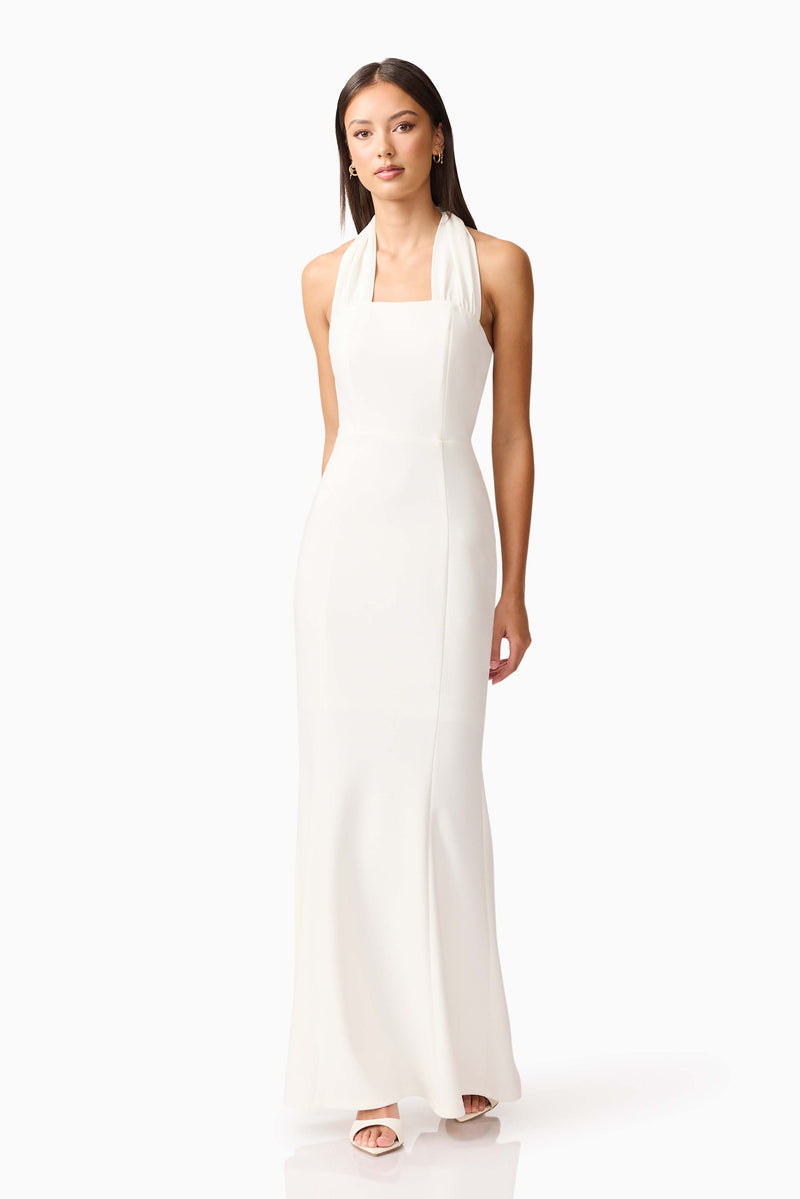 Brunette model wearing the Mira Halter Gown in White posed shot 
