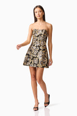 Brunette model wearing the Celeste Strapless Mini Dress in Black and Gold posed shot