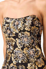 Brunette model wearing the Celeste Strapless Mini Dress in Black and Gold detail shot