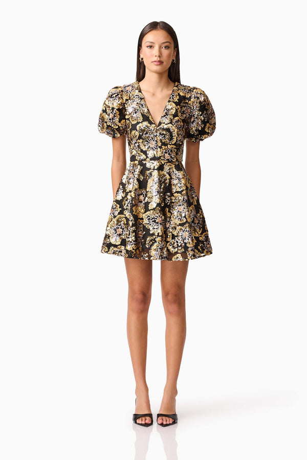 Brunette model wearing the Celeste Puff Sleeve Mini Dress in Black and Gold front shot