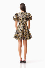 Brunette model wearing the Celeste Puff Sleeve Mini Dress in Black and Gold back shot