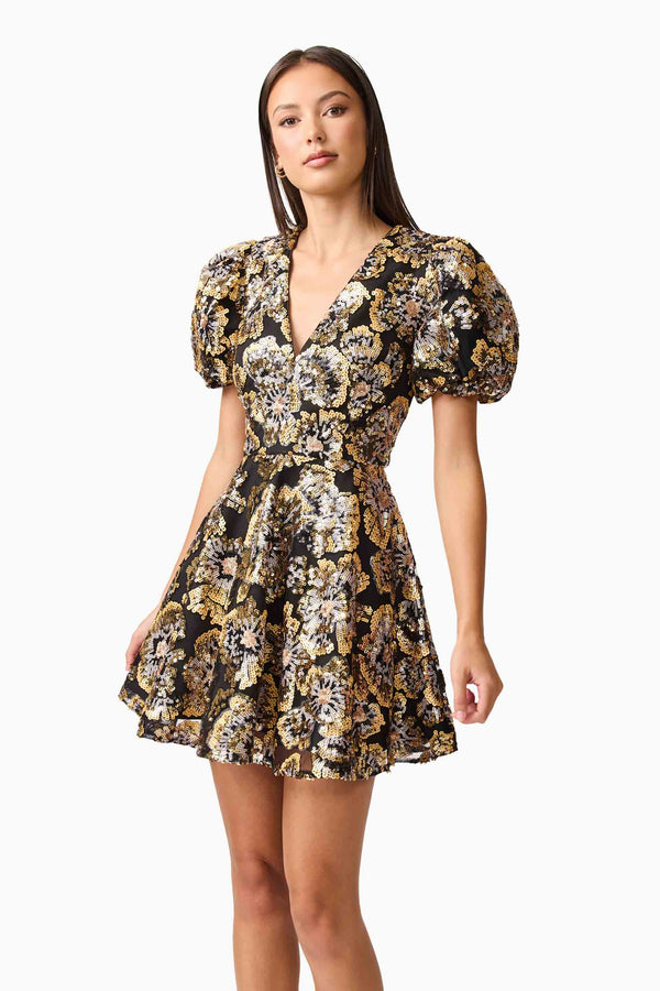 Brunette model wearing the Celeste Puff Sleeve Mini Dress in Black and Gold close up shot