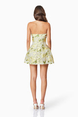 Brunette model wearing the Darner Strapless Mini Dress in Green Floral back shot