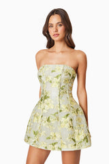 Brunette model wearing the Darner Strapless Mini Dress in Green Floral close up shot