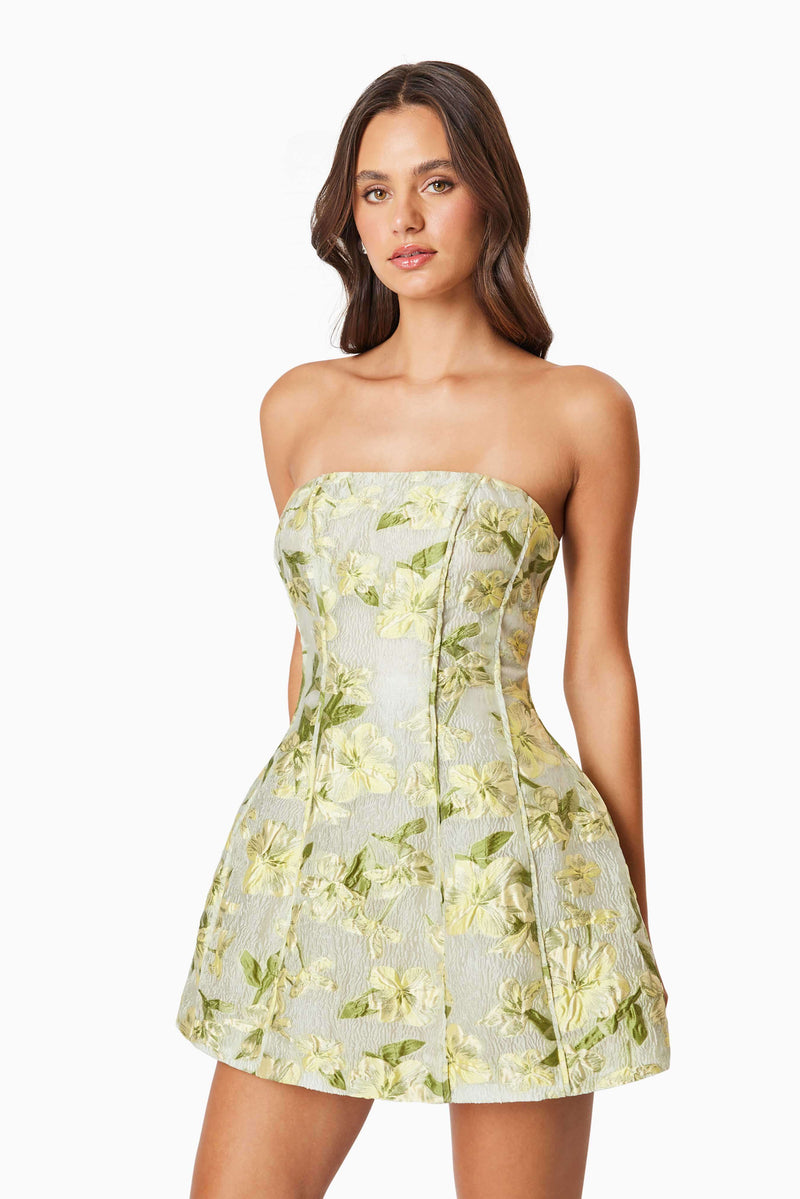 Brunette model wearing the Darner Strapless Mini Dress in Green Floral close up shot