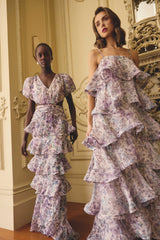Models wearing Rosaria Tiered Gown in Purple Floral & Rosaria Short Sleeve Gown in Purple Floral to a garden wedding 