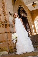 Brunette model wearing the Evelin Halter Gown in White campaign shot