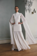 Brunette model wearing the Odelia Cape Sleeve Gown in White campaign shot
