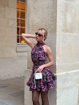 Brunette Model wearing the Estelle Halter Mini Dress in Black & Pink Floral campaign shot