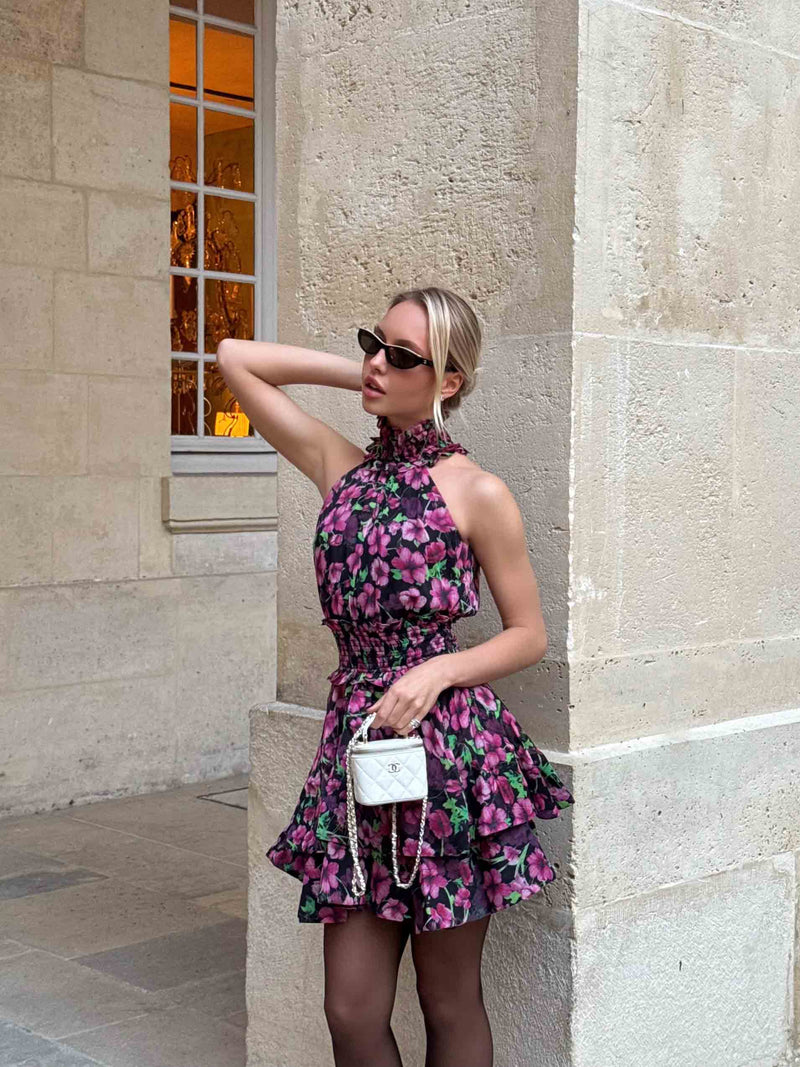 Brunette Model wearing the Estelle Halter Mini Dress in Black & Pink Floral campaign shot