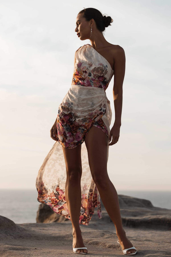 Brunette model wearing Perla Hilo One Shoulder Gown in Floral looking away campaign shot