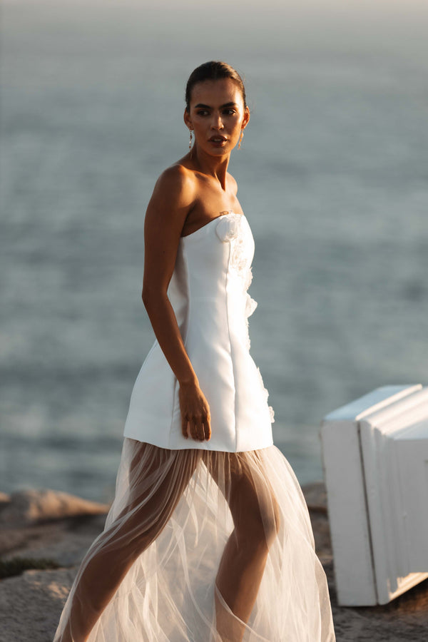 Brunette model wearing Oleander Strapless Maxi Dress In White looking away campaign shot