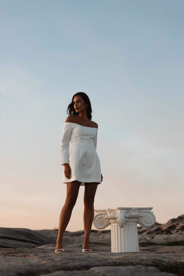 model wearing Vida Off The Shoulder Day Mini Dress In White campaign shot