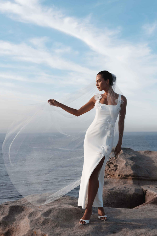 Blonde model wearing Emberlyn Gown in White campaign looking away shot