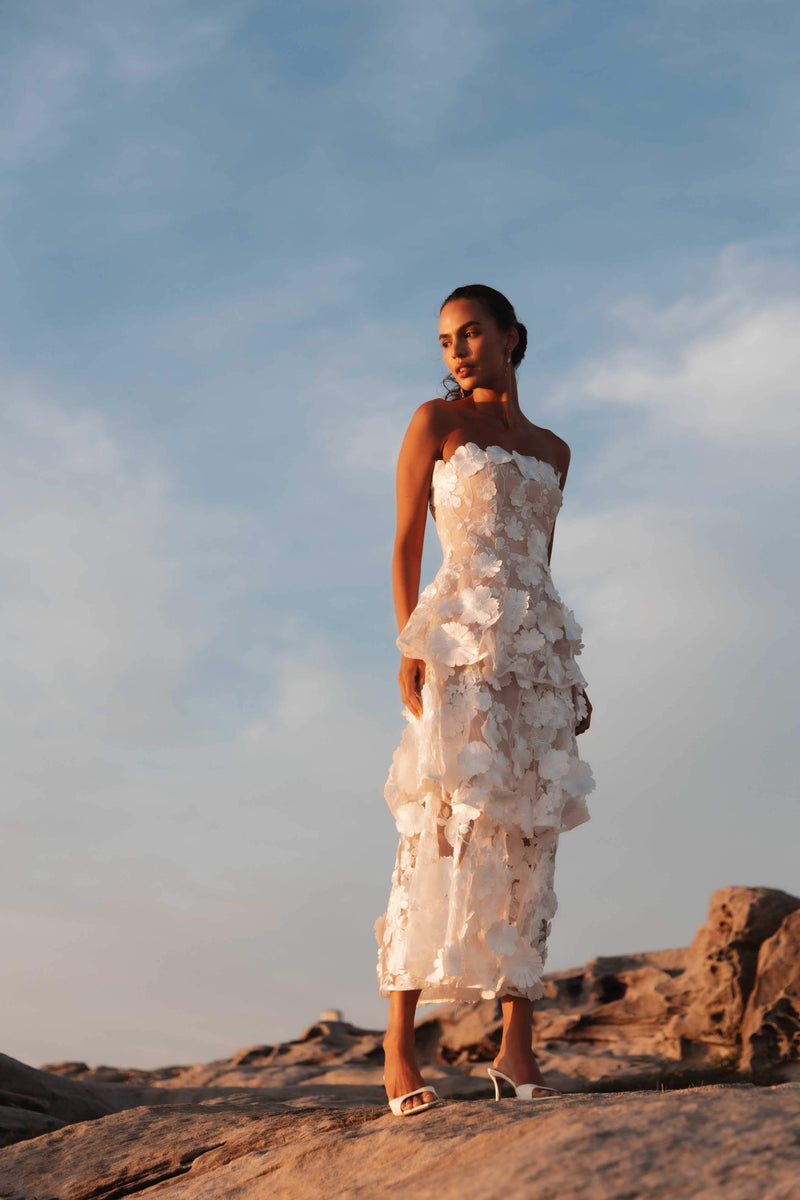Brunette model wearing Selene Maxi Tiered 3D Dress in White posed campaign shot looking away