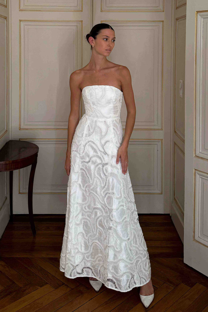 Brunette model wearing Elara Beaded Gown in White front looking away shot