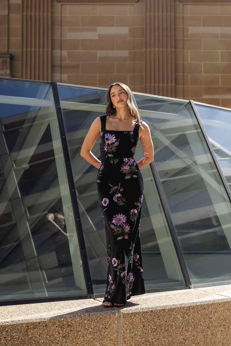 Brunette model wearing the Clio Sequin Gown in Black posed campaign shot