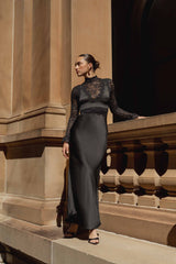 Brunette model wearing the Margot Long Sleeve Gown in Black campaign looking away shot
