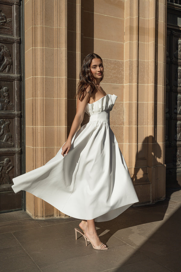 Brunette model wearing the Laurel Sleeveless Maxi in White twirl shot