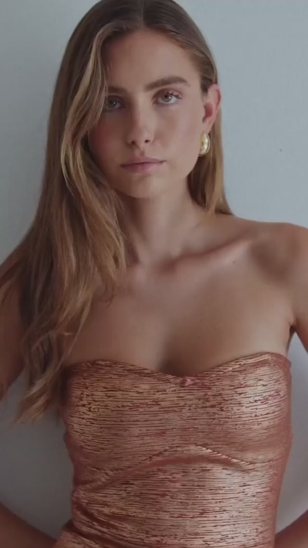 Brunette model's wearing the Rhian Strapless Midi in Orange & Rhian Fitted Mini Dress in Orange campaign video